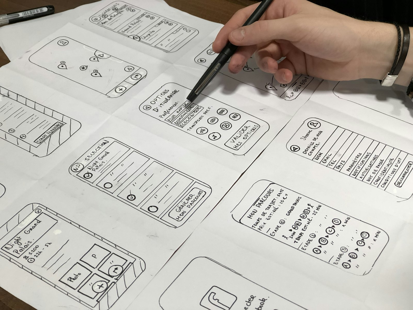 A hand sketching layout wireframes in pencil on paper