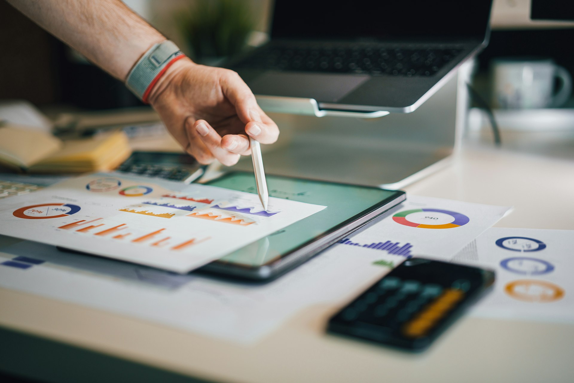 Professional working at a screen showing charts and data